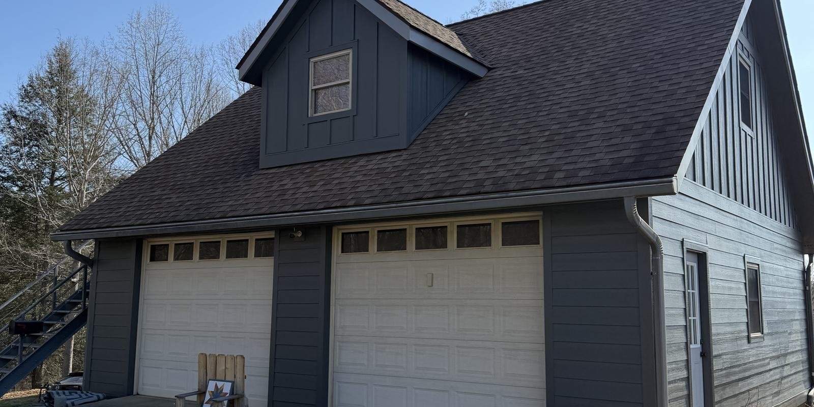 Gray board-and-batten gable above a new shingle roof