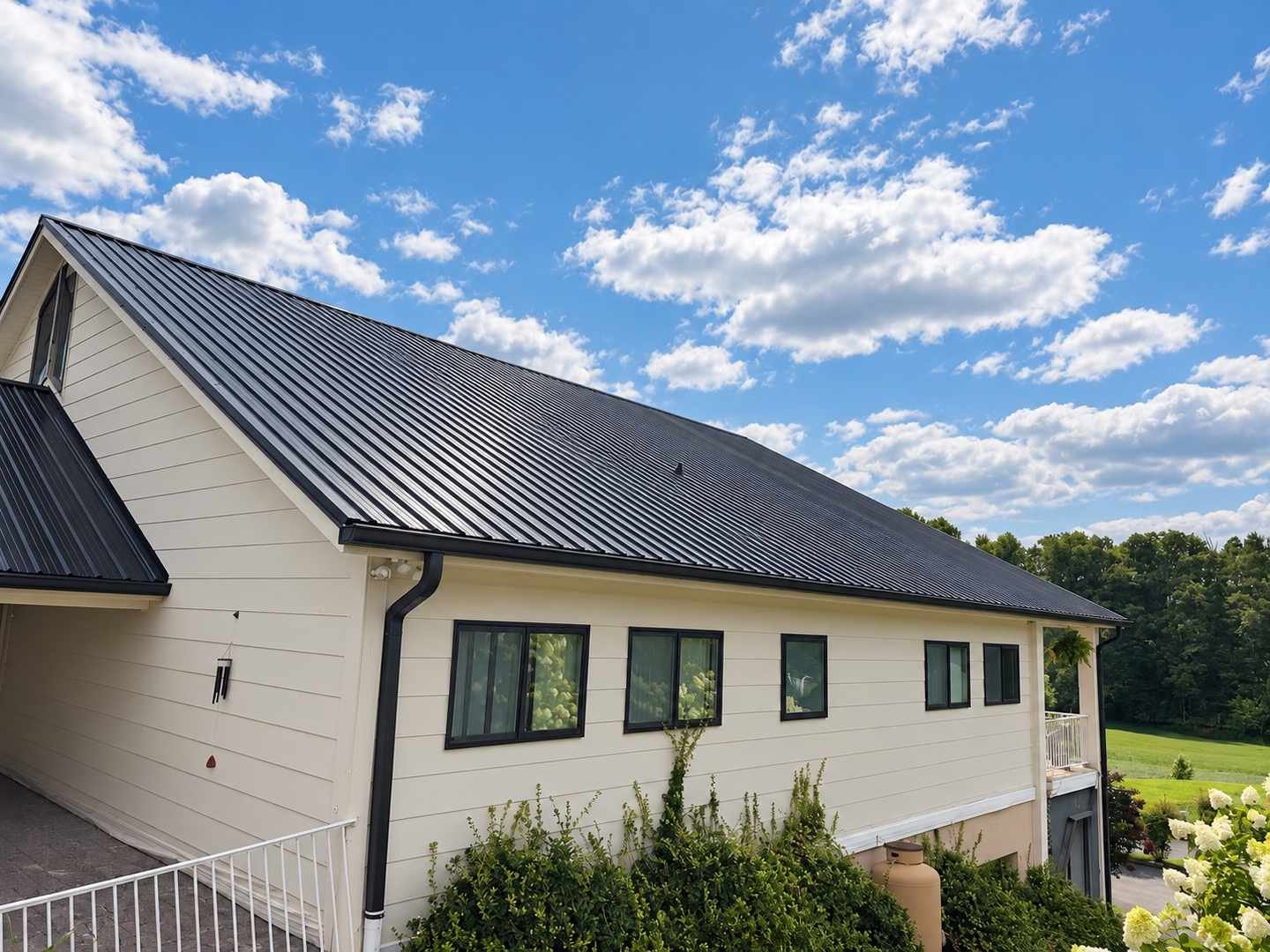 Finished black Tuff-Rib metal roof on a cream-sided home